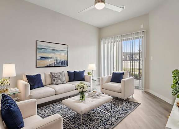 A living room with a white couch, a coffee table, and a painting on the wall.