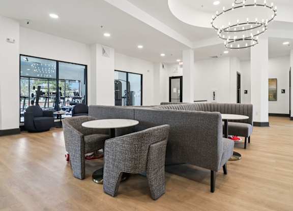 A modern waiting area with grey chairs and a white table.