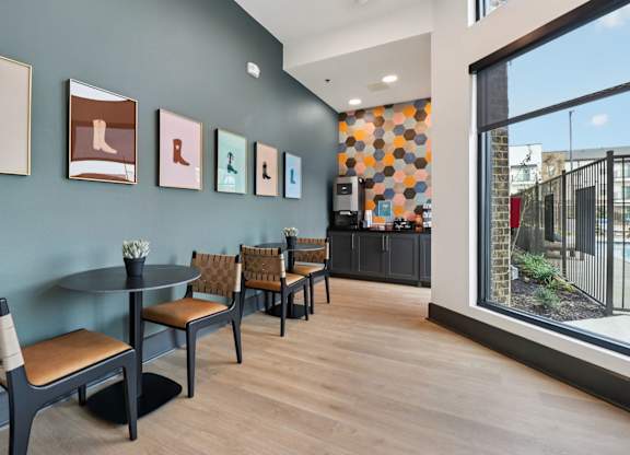 A room with a table and chairs and pictures on the wall.
