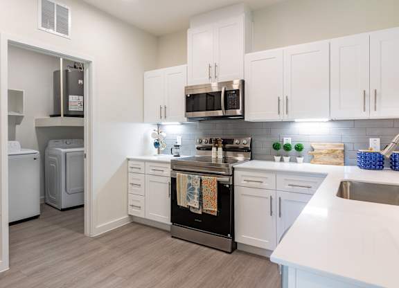 A kitchen with white cabinets and a black oven.