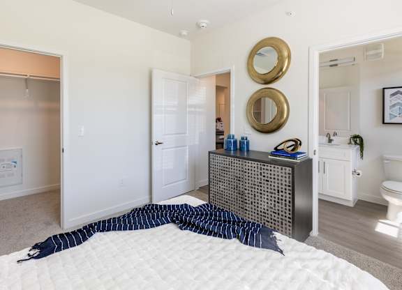 A bedroom with a bed, dresser, and mirror.