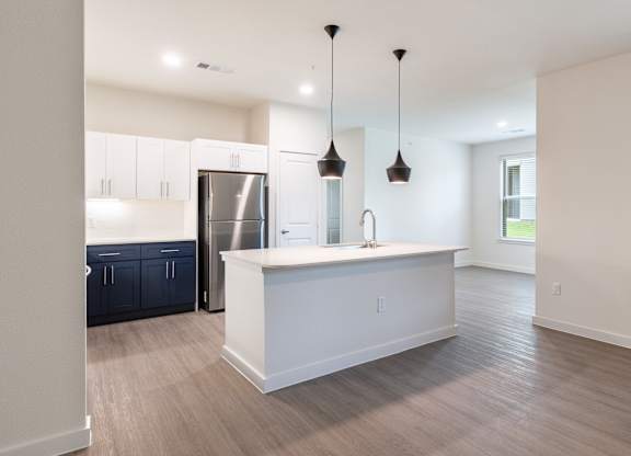 A kitchen with a white island and a refrigerator.