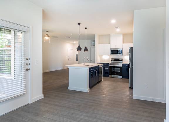 A kitchen with a white island and dark blue cabinets.