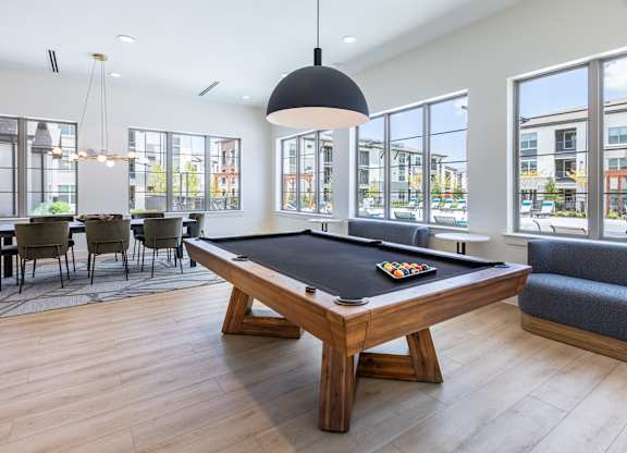 A pool table in a room with a view of the city.