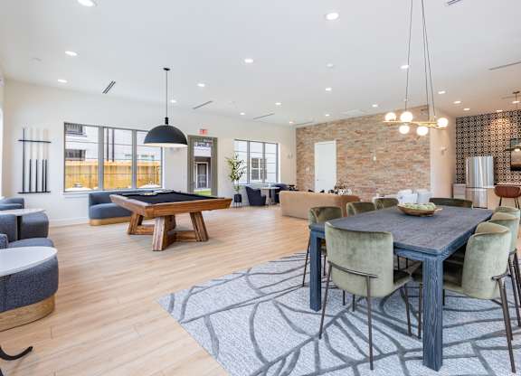 A modern dining room with a large table and chairs.