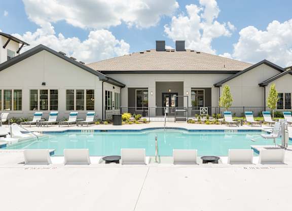 A large house with a pool in front.