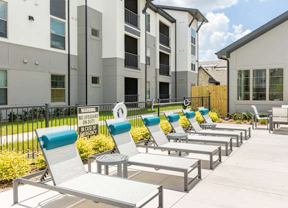 A row of sun loungers are set up outside a building.