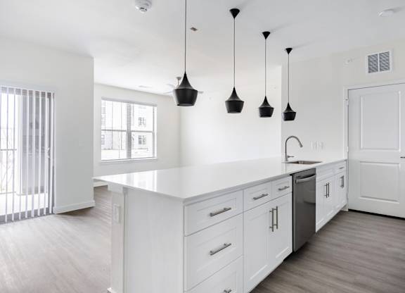 A kitchen with white cabinets and a white counter top.