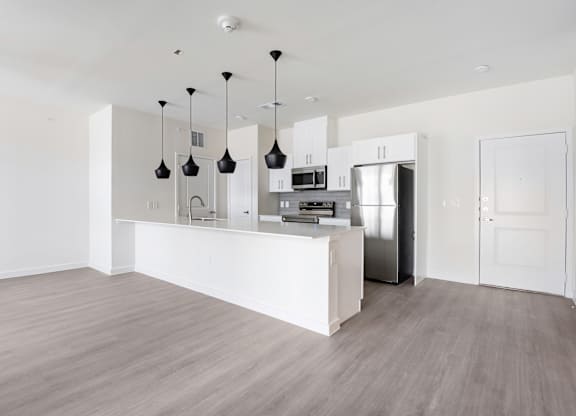 A kitchen with a white counter and a refrigerator.