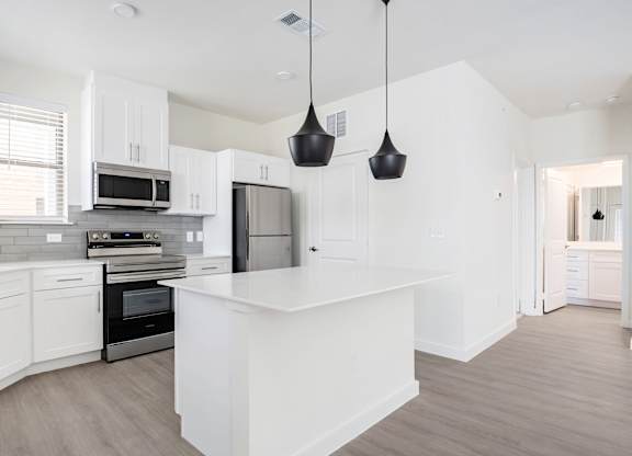 A modern kitchen with white cabinets and a central island.