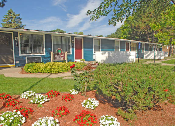 A garden in front of a row of trailer homes.