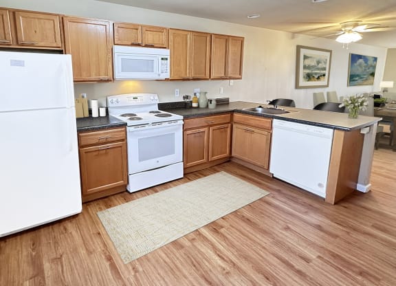 a large kitchen with white appliances and wooden cabinets