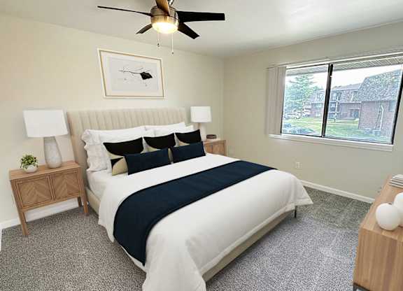 A bedroom with a bed, nightstand, and window.