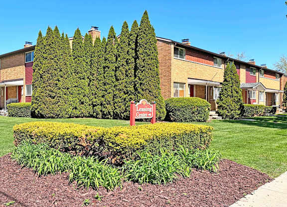 A landscaped garden in front of a building with a sign that says "Ladies.".