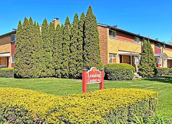 A Leasing Center sign is in front of a building with a green lawn.