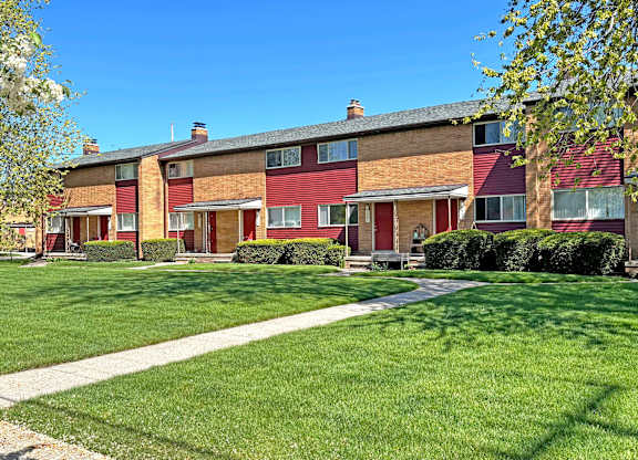 A row of houses with a green lawn in front.