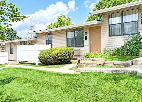 A house with a white fence and green lawn.