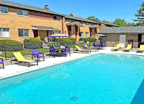 A large swimming pool surrounded by lounge chairs and umbrellas.