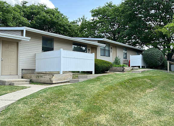 A grassy area in front of a row of houses.