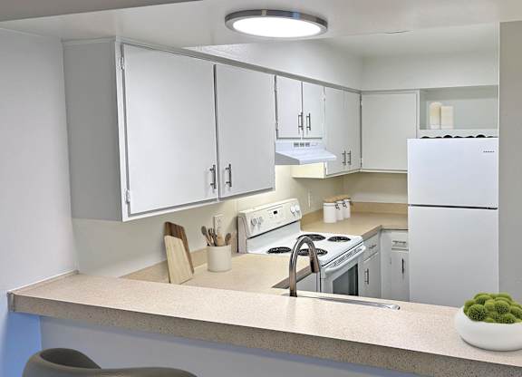 A modern kitchen with white appliances and cabinets.