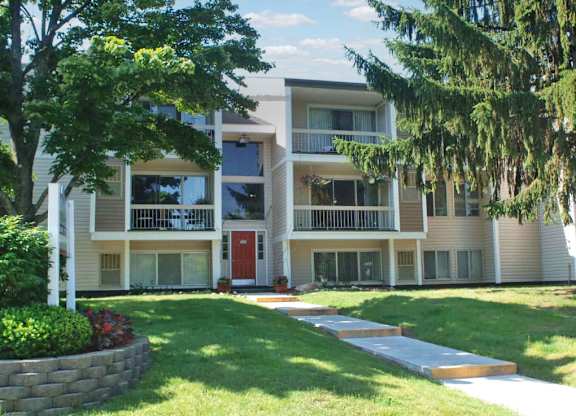 Apartment building with a red door and a white flag on the left.