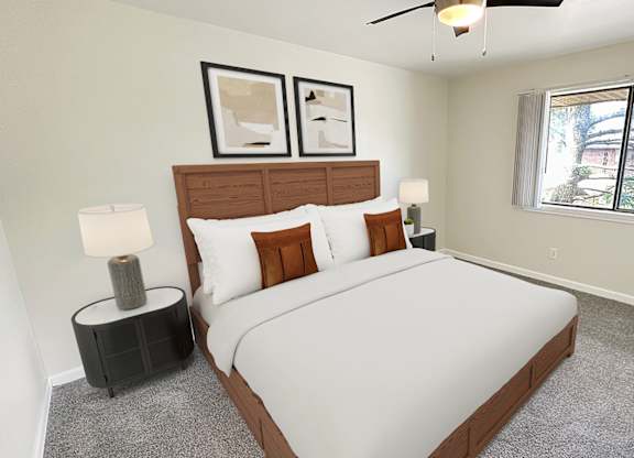 A bedroom with a large bed, two lamps, and two picture frames on the wall.