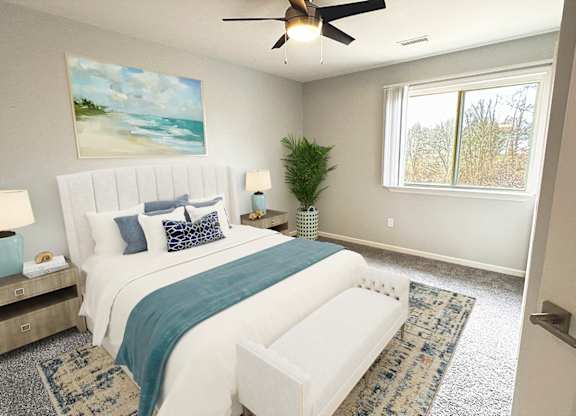 A bedroom with a large bed and a ceiling fan.