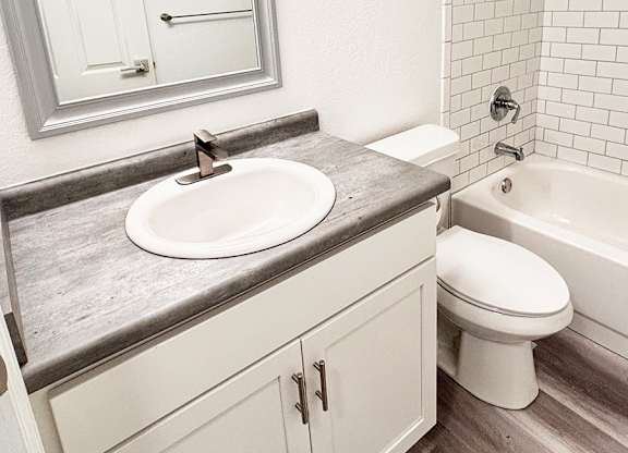 A bathroom with a sink, toilet, and bathtub.