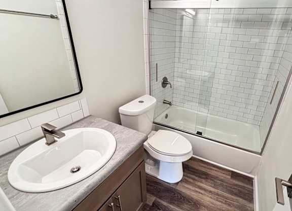 A bathroom with a toilet, sink, and shower.