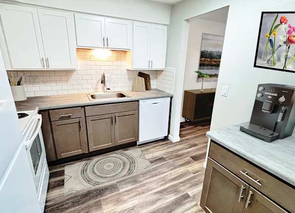 A kitchen with a white refrigerator and wooden cabinets.