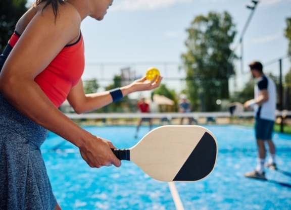A woman is playing tennis in a pool.