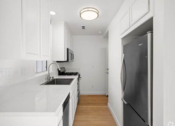 A kitchen with white cabinets and a black fridge at Westmont Place Townhomes Apartments, Santa Cruz, 95060
