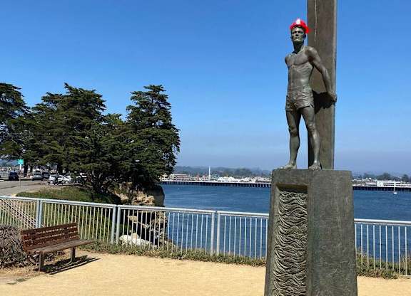 A statue of a man stands on a pedestal by the water at Westmont Place Townhomes Apartments, California