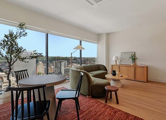 A living room with a view of the cityscape outside the window at 7 West 7th Apartments, Cincinnati, OH