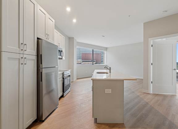 A kitchen with a refrigerator, sink, and cabinets at 7 West 7th Apartments, Cincinnati