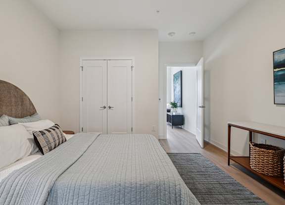 A bedroom with a large bed and a painting on the wall at 7 West 7th Apartments, Cincinnati, 45202