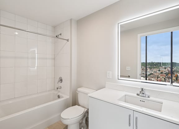 A white bathroom with a toilet, sink, and tub at 7 West 7th Apartments, Ohio, 45202