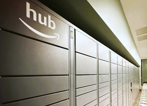 A row of Amazon hub lockers are lined up in a hallway.