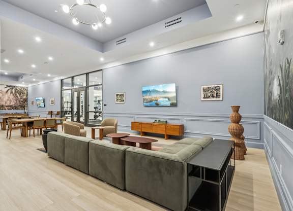 A living room with a grey couch and a wooden table at LiveWell Apartments, Pittsburgh 15222