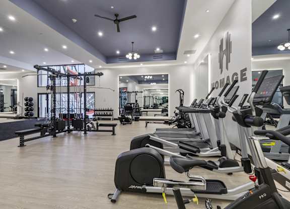 A gym with a variety of equipment including treadmills, stationary bikes, and weight machines. at LiveWell Apartments, Pennsylvania