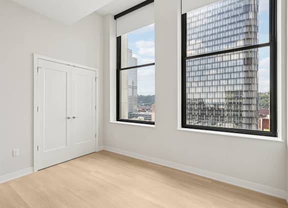 A room with a large window and a view of a cityscape at LiveWell Apartments, Pittsburgh