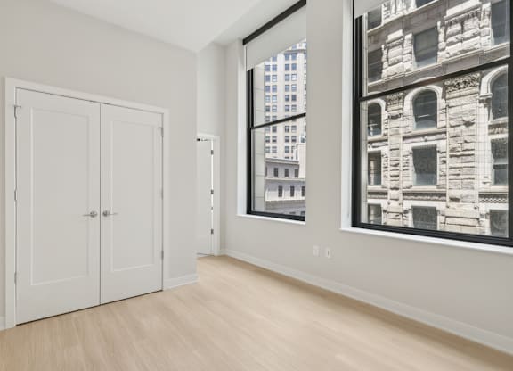 A room with a white door and a large window with a black and white picture on the wall at LiveWell Apartments, Pittsburgh, PA
