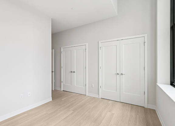 Three white doors are in a room with wood floors at LiveWell Apartments, Pennsylvania, 15222