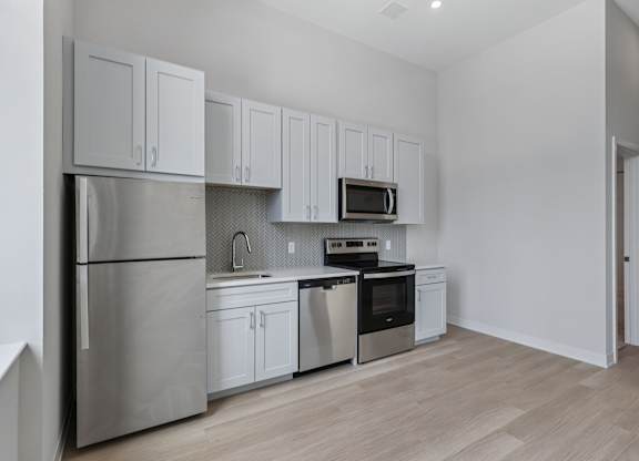 A kitchen with white cabinets and stainless steel appliances. at LiveWell Apartments, Pittsburgh 15222