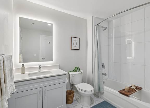 A white bathroom with a toilet, sink, and bathtub. at LiveWell Apartments, Pittsburgh, Pennsylvania