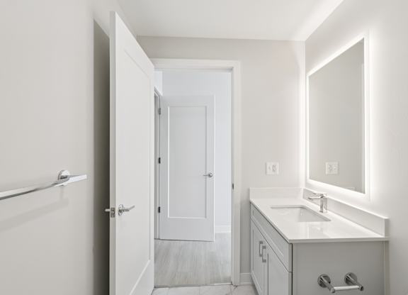 A white bathroom with a sink, mirror, and towel rack. at LiveWell Apartments, Pittsburgh, PA, 15222
