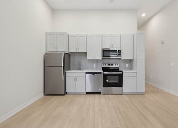 A kitchen with white cabinets and stainless steel appliances at LiveWell Apartments, Pittsburgh 15222