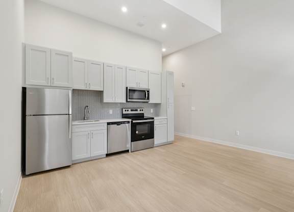 A kitchen with white cabinets and stainless steel appliances. at LiveWell Apartments, Pittsburgh, Pennsylvania