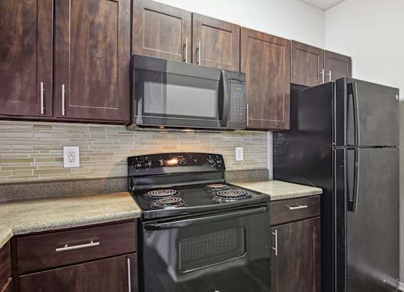 A kitchen with a black stove and refrigerator.