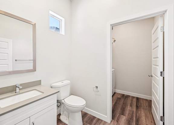 Baseline on 16th townhome bathroom with a toilet, sink, and mirror.